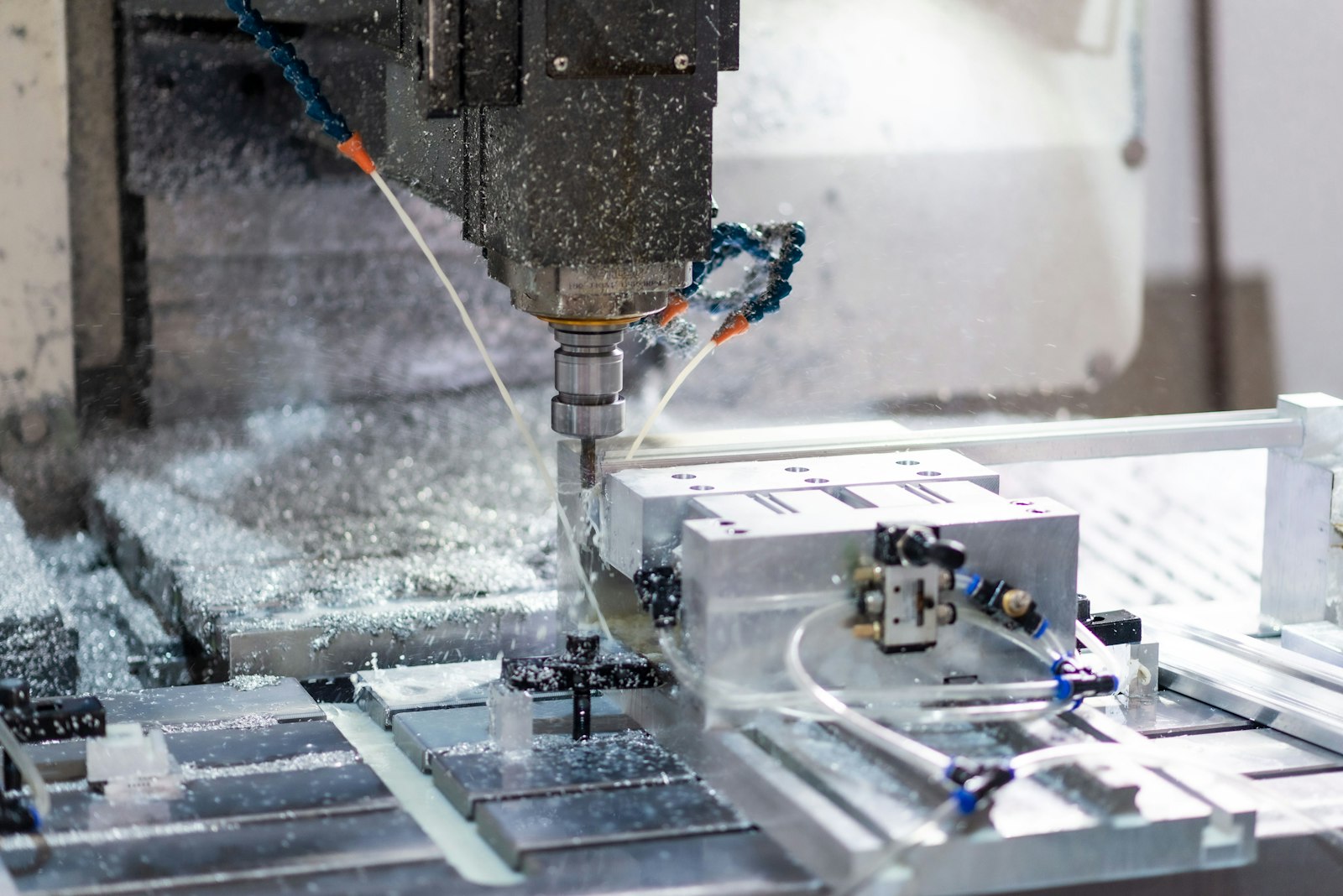 A CNC machining centre milling an aluminium part under coolant
