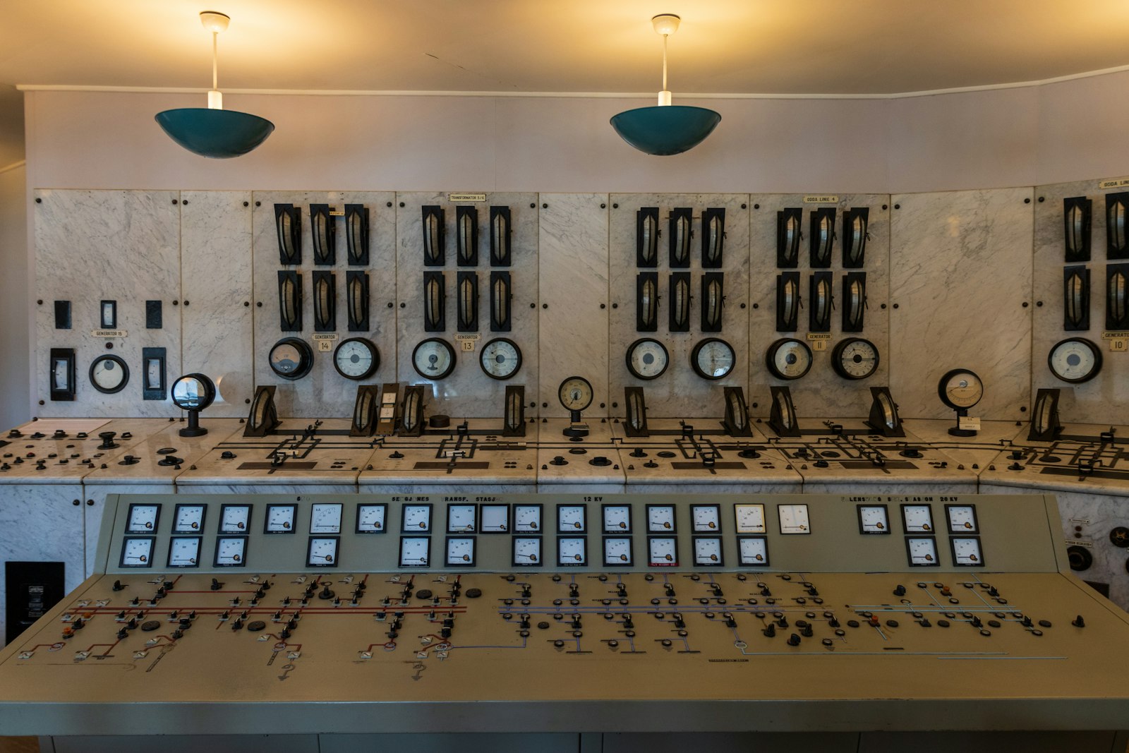 An industrial control room lined with instrument panels